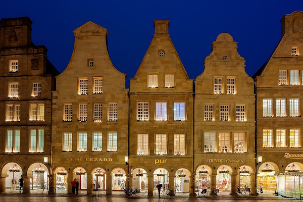 Abendaufnahme der beleuchteten Giebelhäuser am Prinzipalmarkt in Münster für Immobilienmakler FREIESLEBEN. Abendaufnahme der beleuchteten Giebelhäuser am Prinzipalmarkt in Münster für Immobilienmakler FREIESLEBEN.